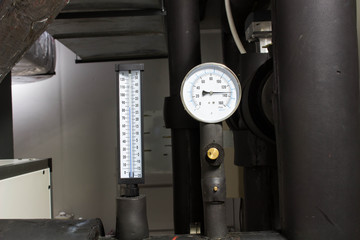 The pressure gage and thermometer in water cold pipe on air condition system