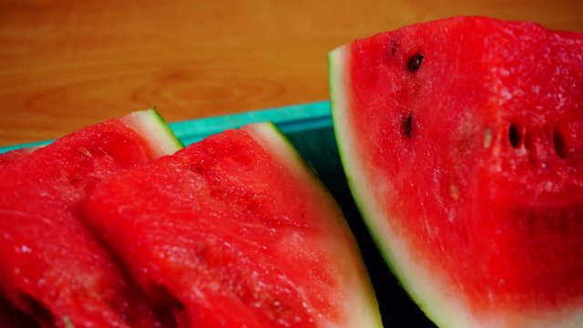 Closeup of fresh red sliced watermelon fruit on green kitchen board. Healthy food organic nutrition. Dolly slider shot 4K