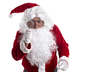 Portrait of santa looked with curiosity through a magnifying glass on camera isolated on white background.