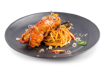 Spicy Pasta with seafood with herbs and spices in Black dish isolated on white background