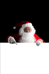 Santa Claus holding a white blank sign isolated on black  background