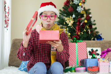 Attractive man with many present boxes sitting at home.