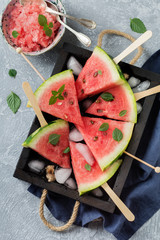 Fresh raw watermelon cut into pieces on  gray stone background. Selective focus. Top view. Copy...