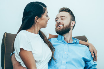 Happy young loving couple sitting on coach