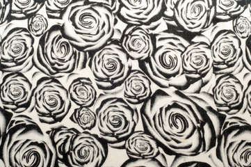 Texture, background, pattern. A woolen scarf, black and white, roses are drawn on a scarf. Woolen black and white fabric
