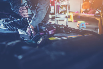 technician working on checking and service car in  workshop garage; technician repair and maintenance engine of automobile in car service
