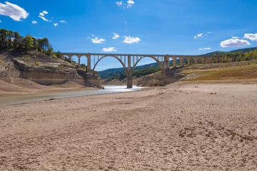 Foto auf Alu-Dibond landscape of dry earth ground and bridge, extreme drought in Entrepenas reservoir, in Guadalajara, Castilla, Spain Europe   © Q
