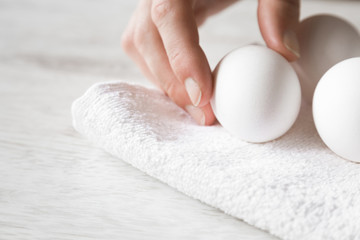 Woman's hand taking a white egg. Food concept.