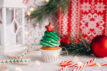 Christmas delicious cupcake in the form of a Christmas tree with balls and a star from the top. Christmas background.