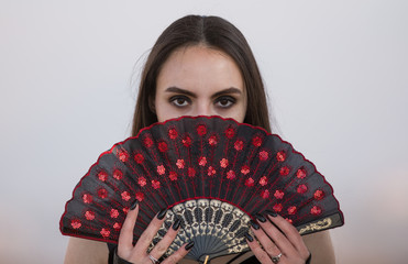 girl with black make-up and with a fan