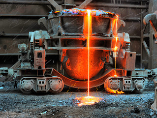 Old slag disposal pots mounted on railway platforms in blast furnace workshop