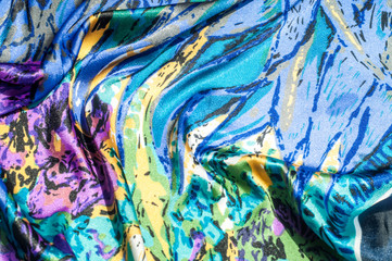 Texture, fabric, background. Women's scarf. Silk fabric is blue, floral pattern. Abstraction