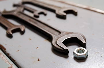several wrenches and screw-nut on the metal background