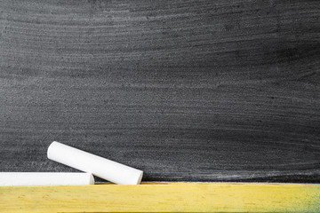 White chalks at the blackboard in classroom. Education concept. Empty place for a text.