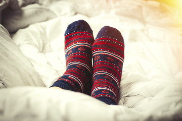 &nbsp; Against the backdrop of a white bed, women's legs are in their socks. Added effect