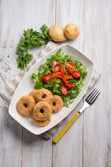 potatoes croquettes with tomatoes and arugula