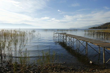 Naklejka premium Old wooden pier by the Ohrid Lake with a cloudy sky on an autumn day