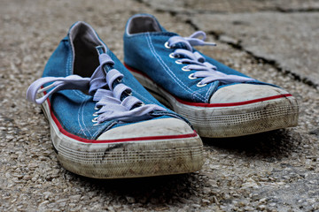 sneakers on the road. road. blue sneakers on asphalt. Teenager's shoes stands on asphalt road