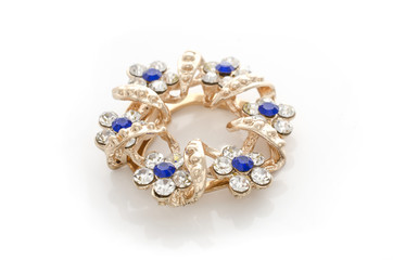 gold round brooch with flowers and diamonds isolated on white