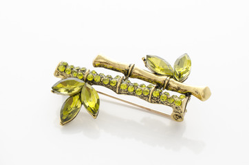 brooch bamboo with emeralds and diamonds isolated on white