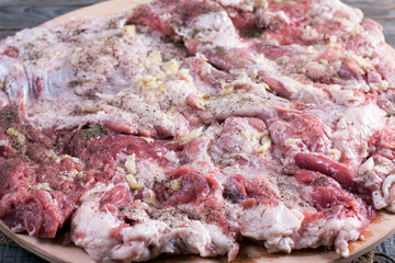 A piece of pork belly with garlic on the table