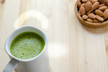 Hot green tea latte in lazy time with almonds nut