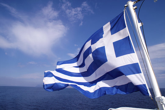  Greece, Aegean sea, Greek flag waving on a ferry boat.