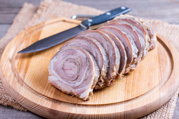 Sliced roasted meat roll on a wooden board