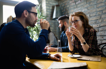 Colleagues from work socializing in restaurant and eating togeth