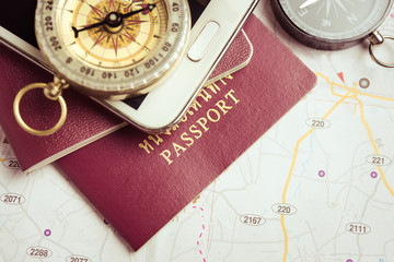 Passport on map with smart phone and compass