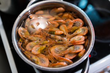 Shrimps boil in pan. Selective focus with shallow depth of field.