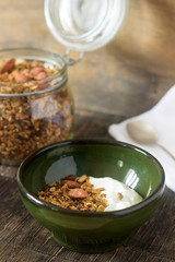 Useful breakfast is yoghurt with granola. Granola with yoghurt in a ceramic bowl and granola in a glass.