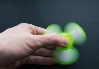 Fidget spinner - anxiety relief toy on dark background. Selective focus.