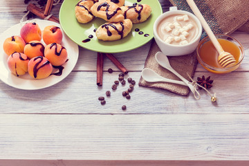 Breakfast of coffee, croissants, apricots, honey, cinnamon and anise