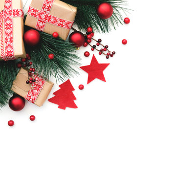 Christmas background. Fir tree branch and red christmas decorations on white background. Top view with copy space.