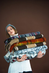 Woman holding heavy pile of blankets