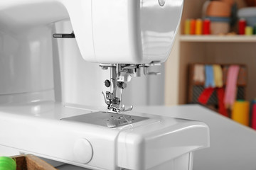 Modern sewing machine on table, closeup