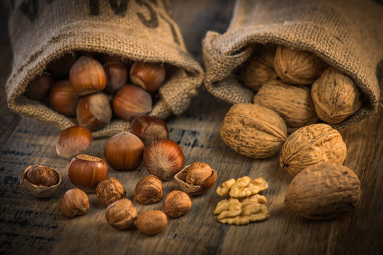 Walnuts and Hazelnut in jute bag on wooden background