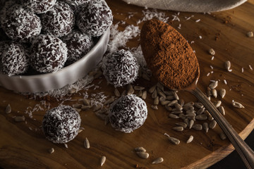 Coconut and chocolate energy balls with spoonful of cacao powder