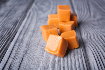 Sweet caramel candies on wooden background