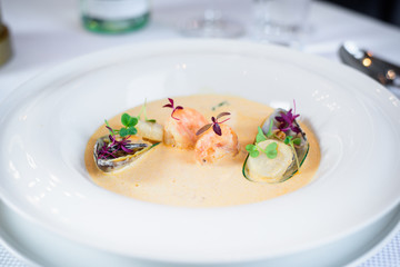 Plate of tasty cream of sea food soup with shrimps and mussels on table