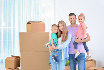 Fototapeta na wymiar Happy family near moving boxes in their new house