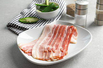 Plate with rashers of bacon on table