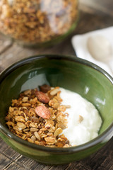 Useful breakfast is yoghurt with granola. Granola with yoghurt in a ceramic bowl and granola in a glass.