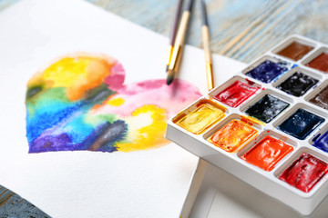 Painting of rainbow heart on table, closeup