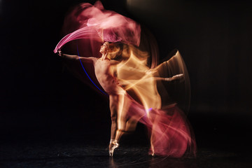 Professional dance studio. Attractive nice skillful woman standing against black background and dancing while being in the professional dance studio