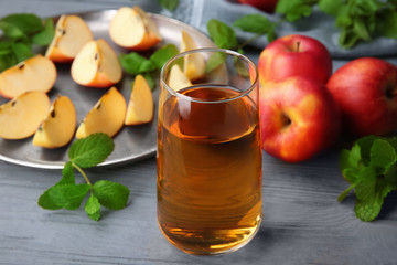 Glass with fresh apple juice on wooden table