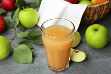 Glass with fresh apple juice on wooden table