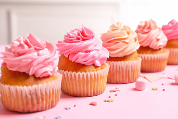 Many yummy cupcakes on table