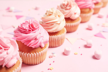 Many yummy cupcakes on color background
